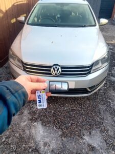 VW Passat key fob being held up in front of silver car in DH8 area
